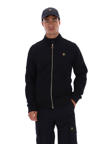 Man wearing a black jacket and pants with a logo on a white background