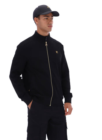 Man wearing a black jacket with a gold zipper and black cap on a white background