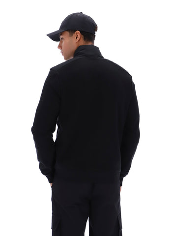 Person wearing a black jacket and cap on a white background