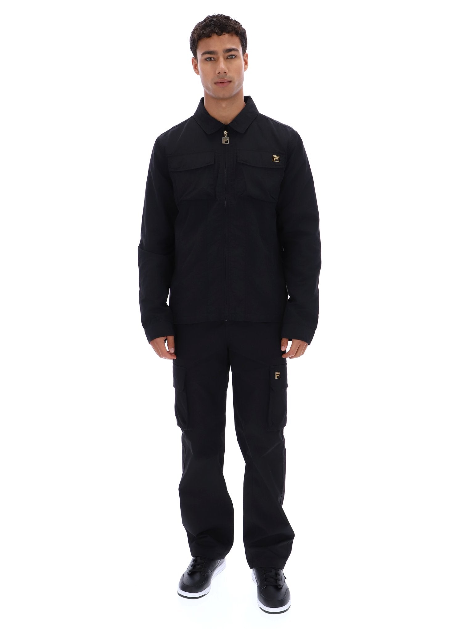 Man wearing a black jacket and pants on a white background