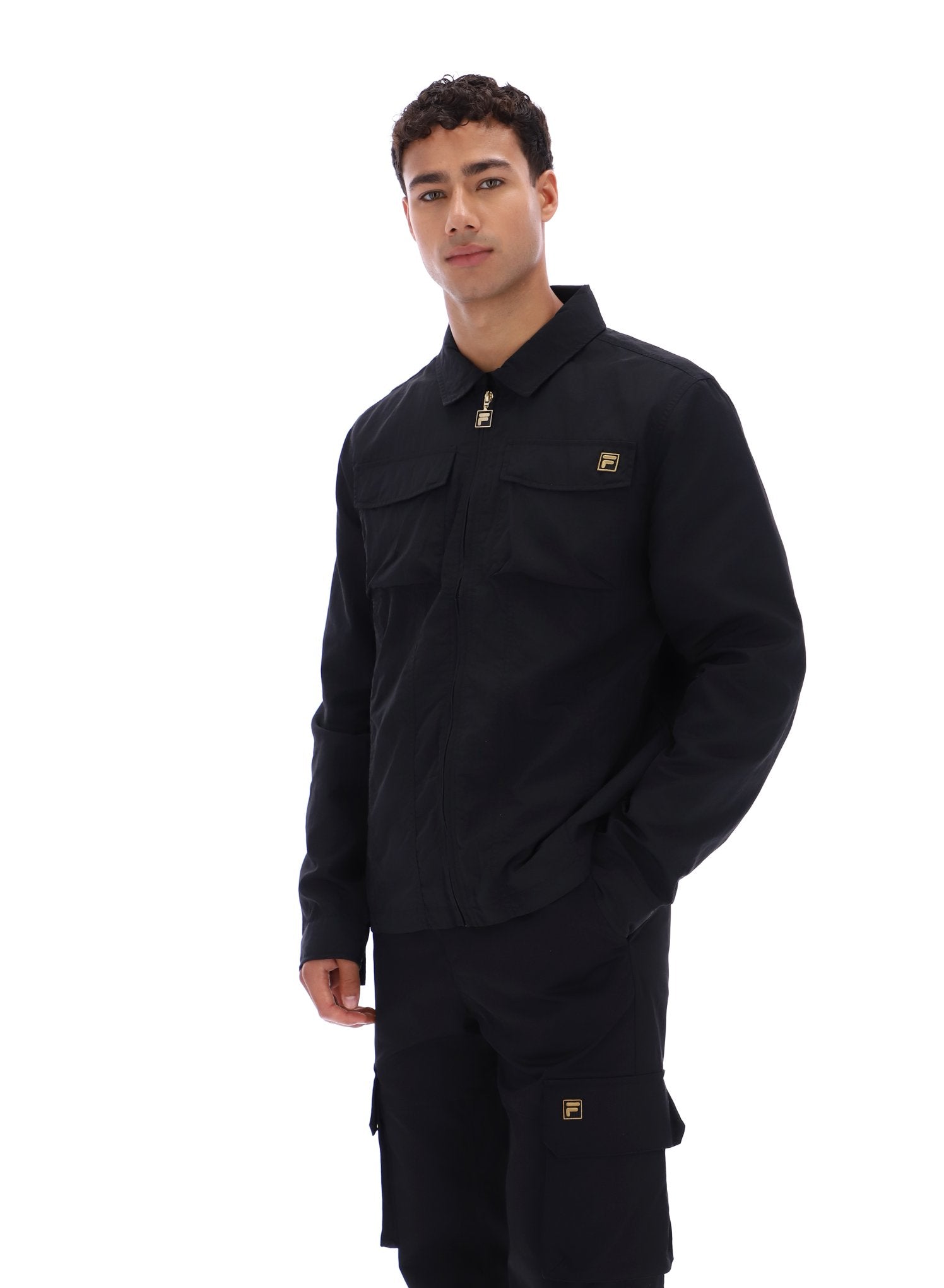 Man wearing a black outfit with a brand logo on a white background