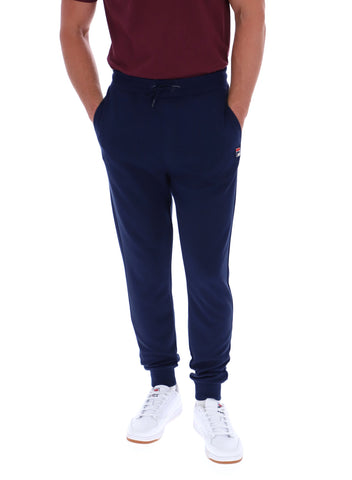 Person wearing navy jogger pants with a brand logo on a white background
