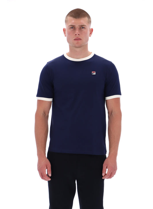 Man wearing a navy blue t-shirt with a small logo on a white background