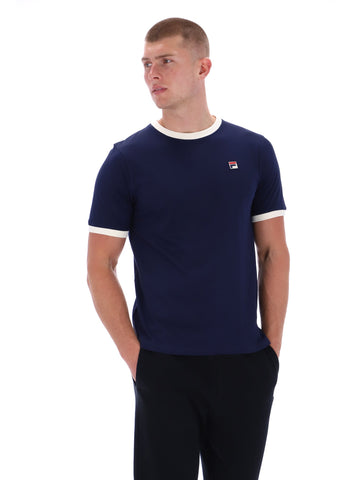 Man wearing a navy blue t-shirt with a small logo on a white background
