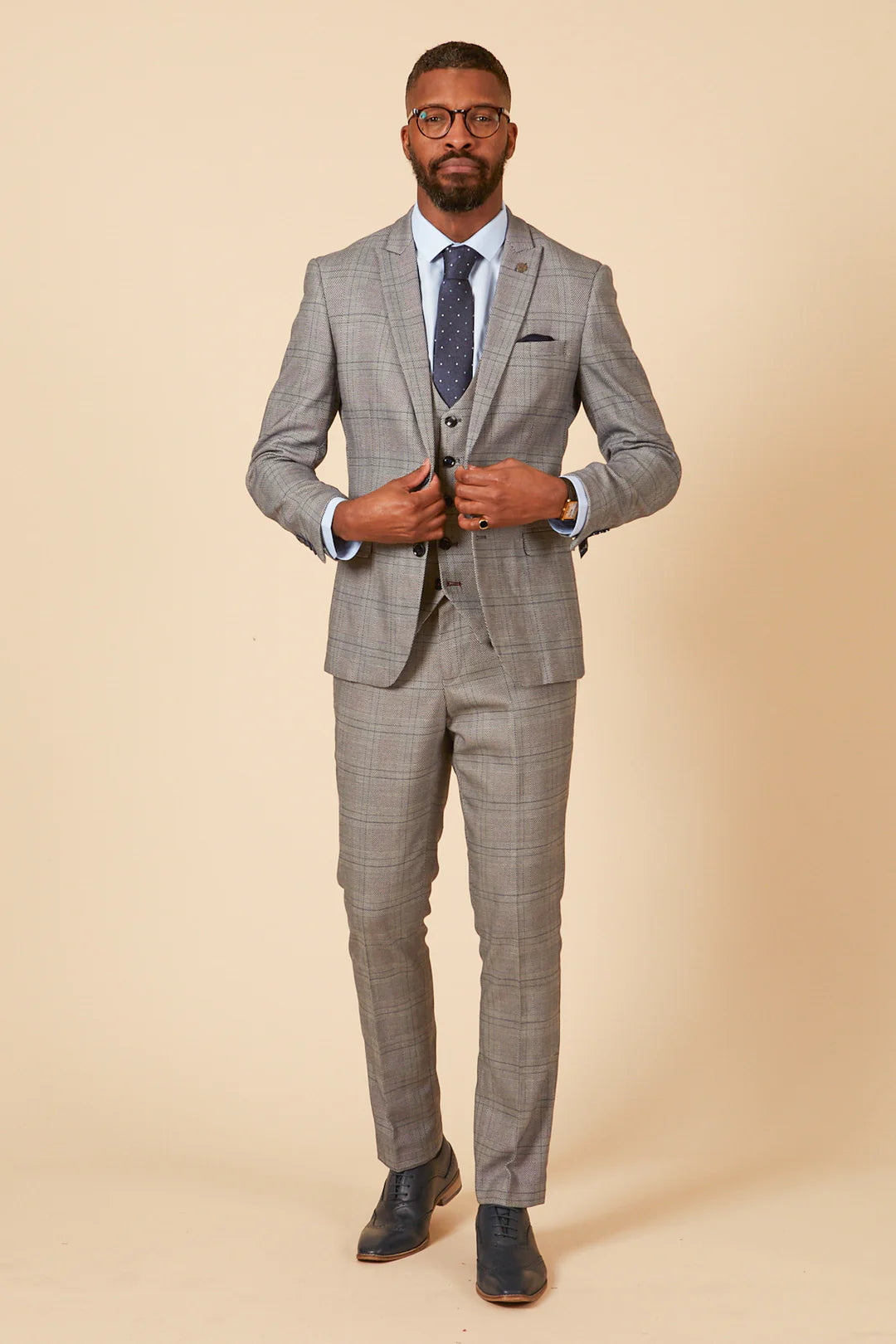 Man wearing a gray checkered suit on a beige background