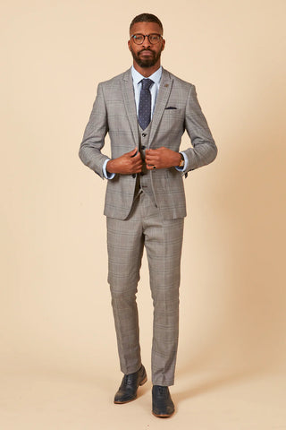 Man wearing a gray checkered suit on a beige background