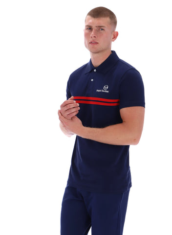 Man wearing a navy polo shirt with a red stripe on a white background
