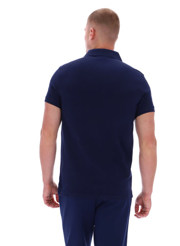 Man wearing a navy blue polo shirt and pants on a white background