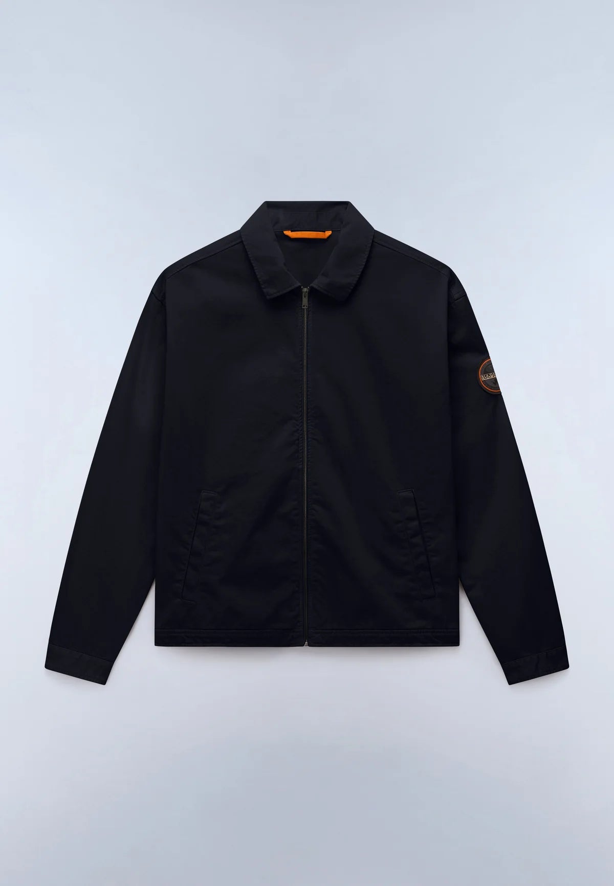 A black zip-up jacket with a pointed collar, displayed flat against a light gray background. It features a small orange logo patch on the left sleeve and a small orange accent inside the collar.