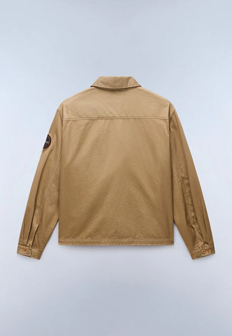 A tan utility jacket shown from the back, featuring a collar, long sleeves, and a small circular patch on the left sleeve, photographed against a light gray background.