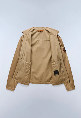 A tan utility jacket shown from the back, featuring a hood, large patch pockets, and a small black brand patch on the lower back and a circular sleeve patch, photographed on a light gray background.