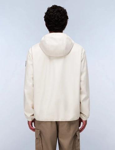 Person wearing a beige puffer jacket and brown pants on a light gray background