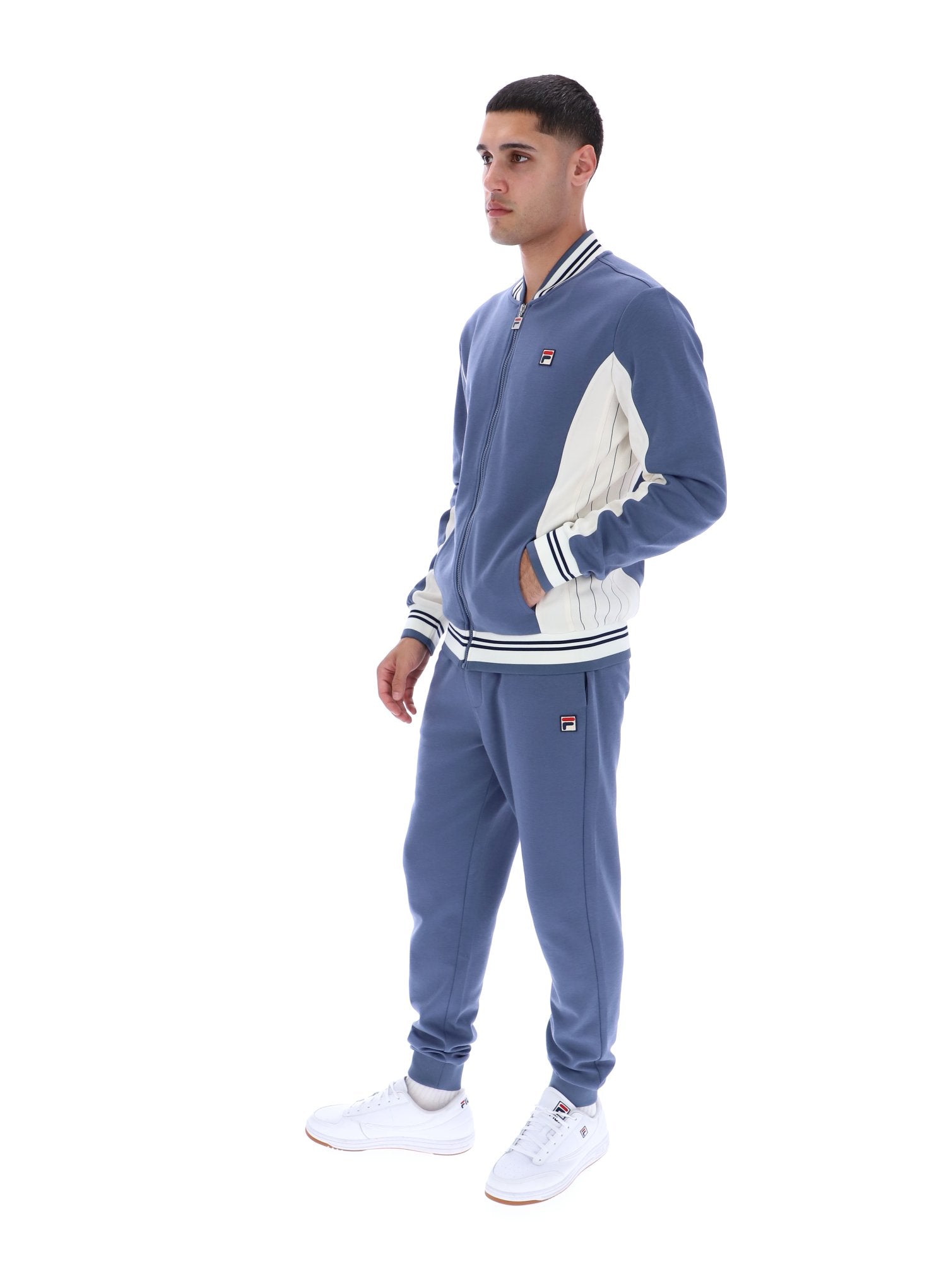 Man wearing a blue tracksuit with white accents on a white background