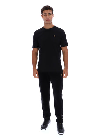 Man wearing a black t-shirt and pants with a brand logo on a white background