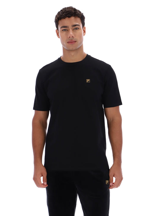 Man wearing a black t-shirt with a small logo on a white background