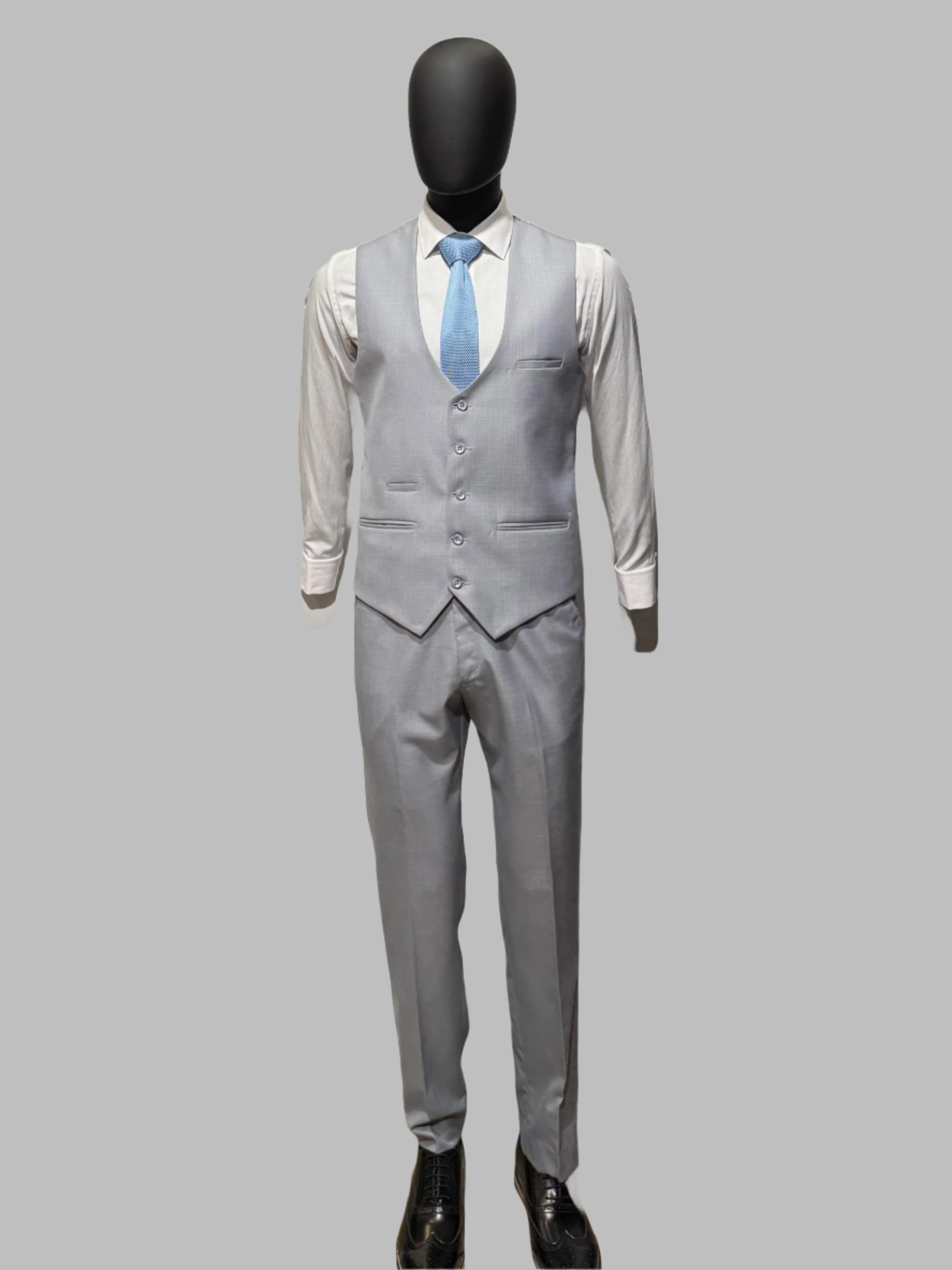 Gray suit with a white shirt and blue tie on a mannequin against a white background