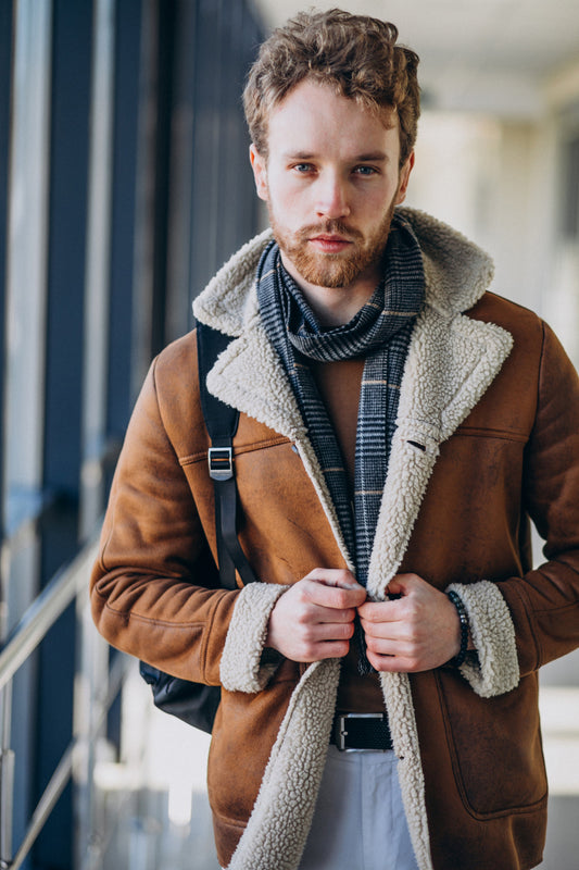 Man wearing a brown shearling jacket with a blurred background