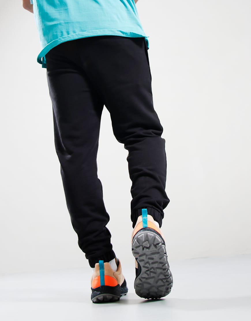 Person wearing black pants and colorful shoes on a white background