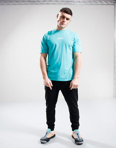 Person wearing a light blue t-shirt and black pants on a white background