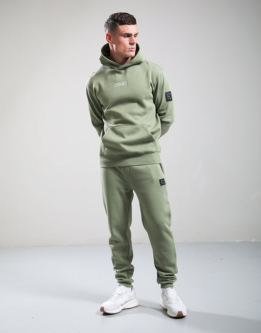 Man wearing a green tracksuit with a plain background
