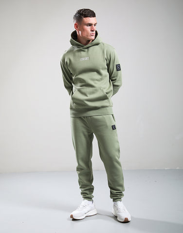 Man wearing a green tracksuit with a plain background