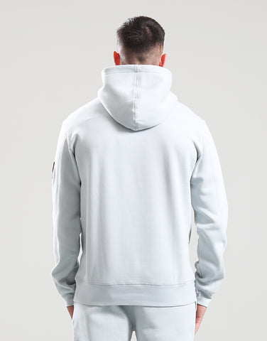 Person wearing a light gray hoodie and pants on a plain background