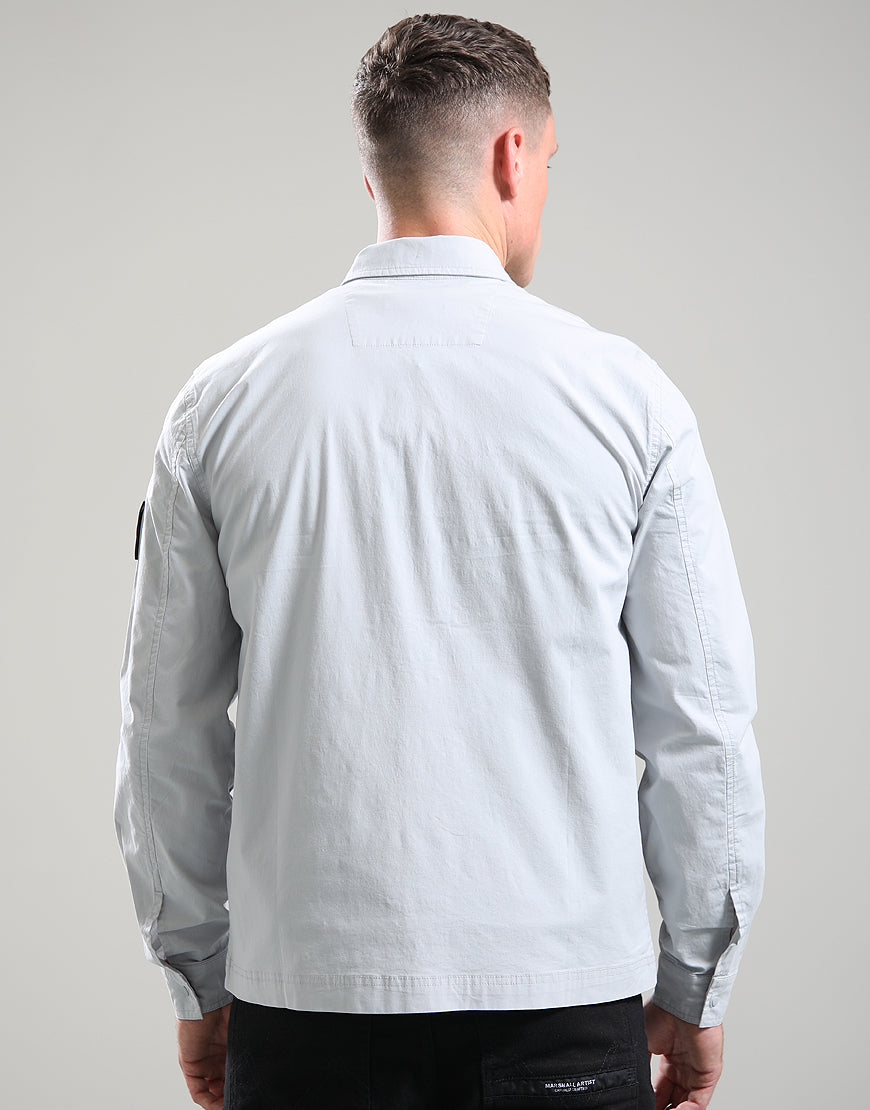 Man wearing a light gray long-sleeve shirt against a plain background