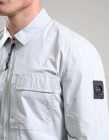 Light gray jacket with a brand patch on a neutral background