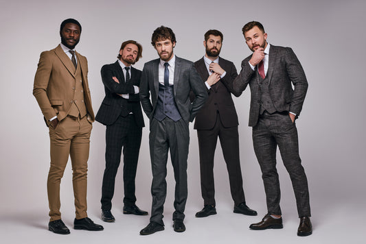 Five men in suits posing together against a plain background
